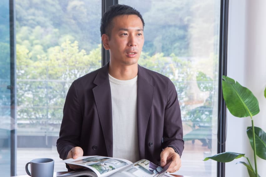 雑誌を広げながら話す男性の室内ポートレート