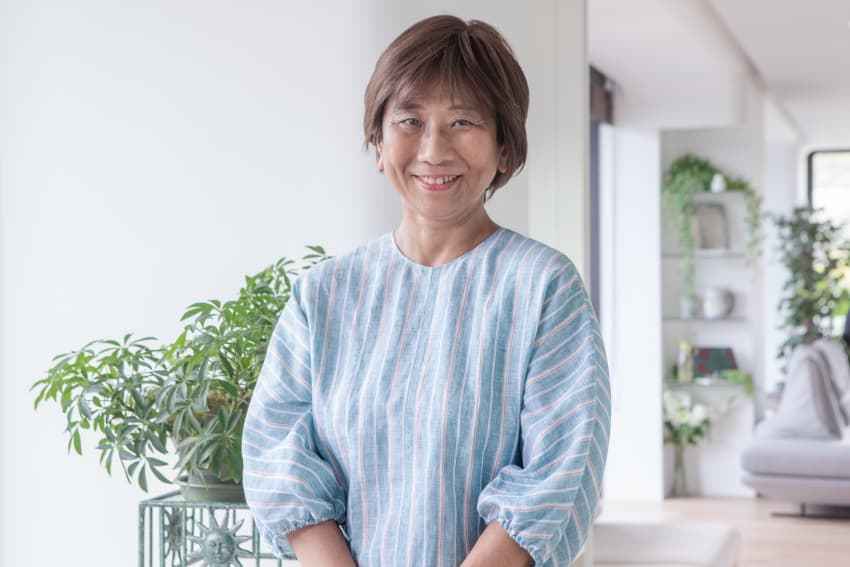 室内で観葉植物を背景に微笑む女性のポートレート